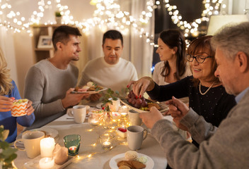 celebration, holidays and people concept - happy family having tea party at home