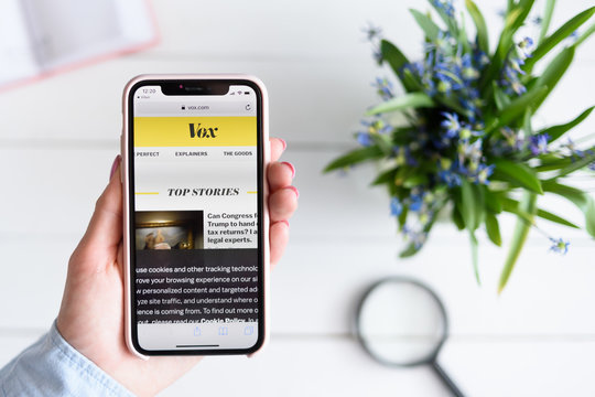 KHARKIV, UKRAINE - April 10, 2019: Apple iPhone X in female hand with vox.com site on the screen.
