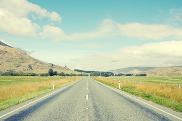 Straight road in New Zealand. Retro filtered colors style.
