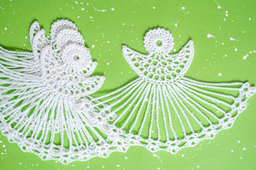 White crocheted Christmas angel from threads on a blue background. New Years winter card. Handmade and creativity. Crochet, measurement with a ruler. cozy new year. flat lay.Creative Handmade.