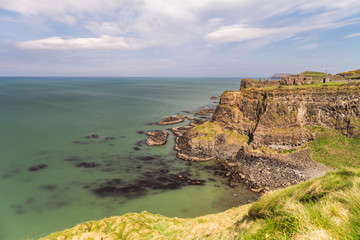 Early morning sunlight over Dunluce Castle at the Causeway Coast of Northern Ireland