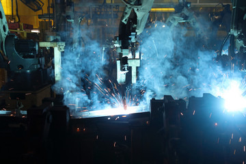 automate wireless Robot arm in smart factory background. Mixed media of welding robot in the...