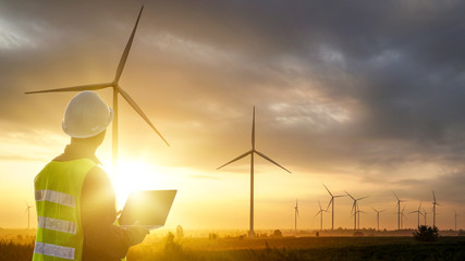 Silhouette of Technician Engineer  at wind turbine electricity industrial in sunset