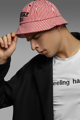 Close-up portrait shot of a short-haired European man dressed in a white top with black lettering,...