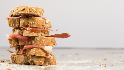 tiered sandwich made with with rye bread and ham