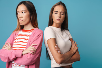 Portrait of multinational displeased women posing with arms crossed