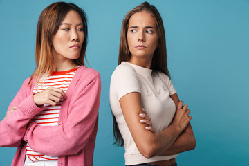 Portrait of multinational resentful women posing with arms crossed