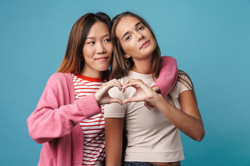 Portrait of multinational satisfied women showing heart gesture