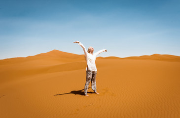 Fototapeta na wymiar Sporty woman in Merzouga dunes of Sahara desert Morocco Africa. Travel and inspiration concept