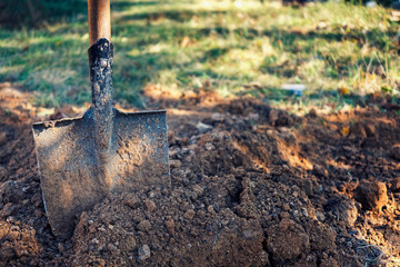 Old spade or shovel stuck in freshly dug earth