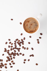 Coffee in a white cup and coffee beans on the table. White background.
