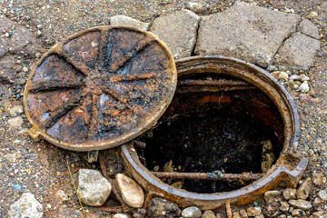 old rusty open sewer manhole, danger