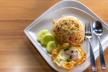 fried rice with shrimp and fried egg on wooden table