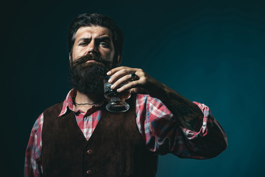 Alcohol concept. Handsome bearded businessman is drinking expensive whisky. Old traditional whiskey drink - gentlemen beverage.