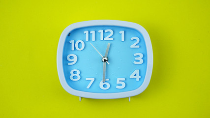 Blue Alarm clock on Yellow background, Copy space for your text, Time concept.