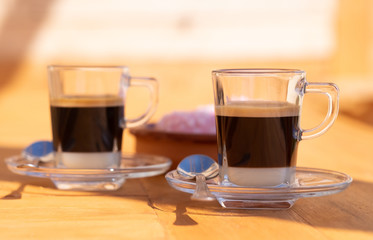 Close-up view of a couple of traditional spanish coffee made with condensed milk and espresso coffee. Focus on the most close cup