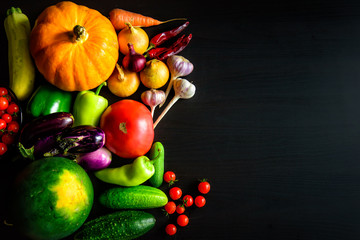 Tasty appetizing fresh autumn seasonal vegetables on dark wooden background top view with copy space. Healthy food, vegetarianism, clean eating. Harvest, gardening, Thanksgiving day concept.