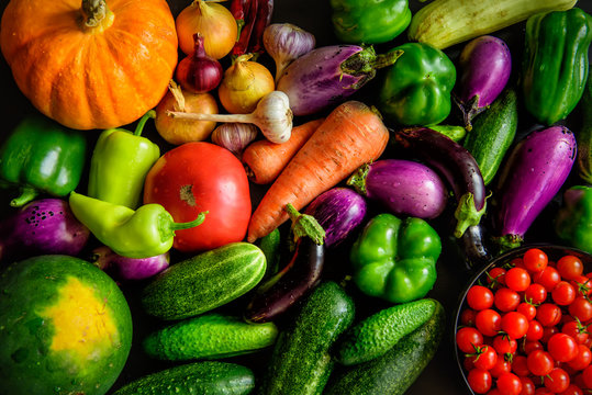 A pile of various vegetables on the table, water drops on fresh vegetables. Harvest from the garden. Vitamins, longevity foods, organic meal.