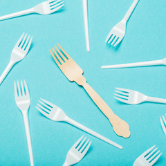 Eco-friendly dishes, wooden and plastic forks on a blue background