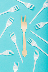 Eco-friendly dishes, wooden and plastic forks on a blue background