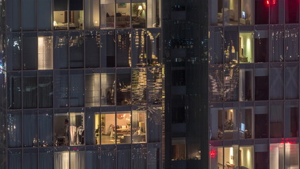 Night view of exterior apartment tower timelapse. High rise skyscraper with blinking lights in windows