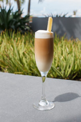 coffee drink Spanish coffee in a glass with a stick of sugar cane
