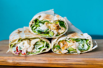 shawarma in pita bread cut on a board on a blue background