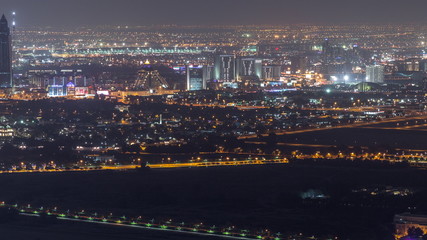 Aerial view to Creek and zabeel district night timelapse with traffic and under construction building with cranes from downtown