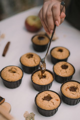 The baker creates cupcakes in molds. Filling biscuits with homemade liquid caramel