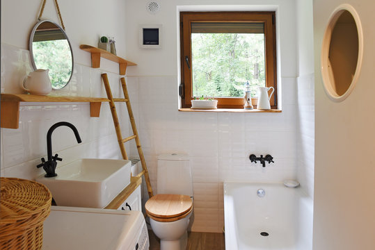 interior of small modern bathroom in white color and wooden decor. Scandinavian and vitage style.