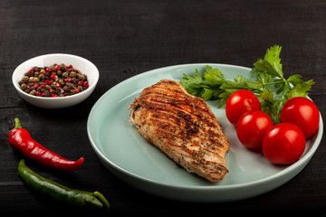 Tasty grilled chicken with fresh tomatoes on a dish