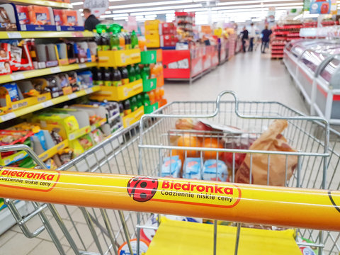 Nowy Sacz, Poland - October 13, 2017: Shopping cart on background of the blurred interior of the Biedronka supermarket. Biedronka is the largest supermarket chain in Poland owned by the Portuguese 