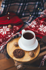 Tea and cookie with festive lights on terrace.