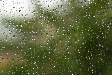Rain drops on a window with selective focus area. Bokeh background concept.