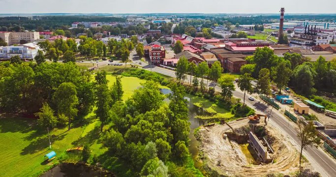 Beautiful nature aerial view of a small town with trees by the old paper factory tower