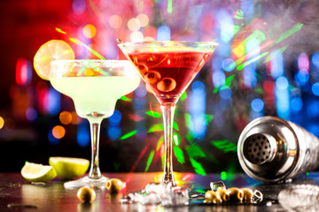 Two glasses with alcoholic drinks on a bar