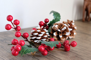 Cones and artificial twig with red berries. Things to decorate the interior in the New Year and Christmas.