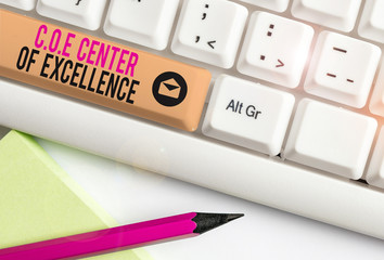 Handwriting text Coe Center Of Excellence. Conceptual photo being alpha leader in your position Achieve White pc keyboard with empty note paper above white background key copy space