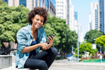 Pretty african american young adult woman with phone