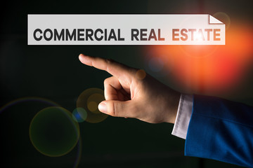 Writing note showing Commercial Real Estate. Business concept for Income Property Building or Land for Business Purpose Isolated hand pointing with finger. Business concept pointing finger