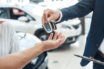 Salesman giving key from rental car to his client