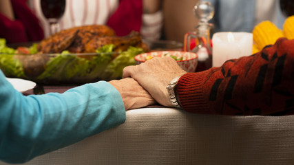 Close-up family holding hands on thanksgiving event