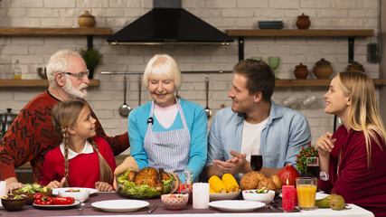 Family generations sitting at the thanksgiving dinner table