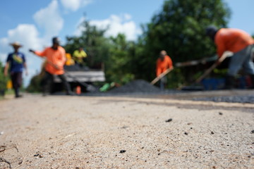 Naklejka premium Repairing a damaged road By adjusting the level with asphalt mixed with small stones (picture blurred)
