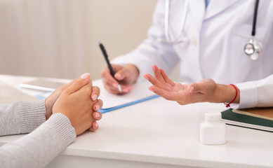 Unrecognizable Female Therapist And Patient Discussing Prescription In Office, Cropped