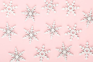 Christmas background. White snow decorations on a pink background.