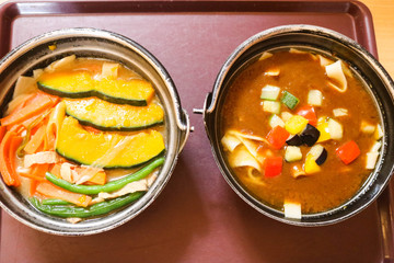 Curry ramen in black bowl with vegetable and Ramen with pumpkin and carrot. Two japanese noodle is delicious. Healthy food concept.