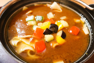 Curry ramen in black bowl and topped with vegetable
