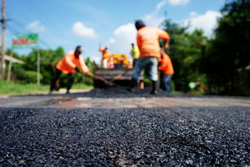 Obraz premium Repairing a damaged road By adjusting the level with asphalt mixed with small stones (picture blurred)