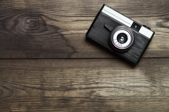 Classic film camera on wooden background.